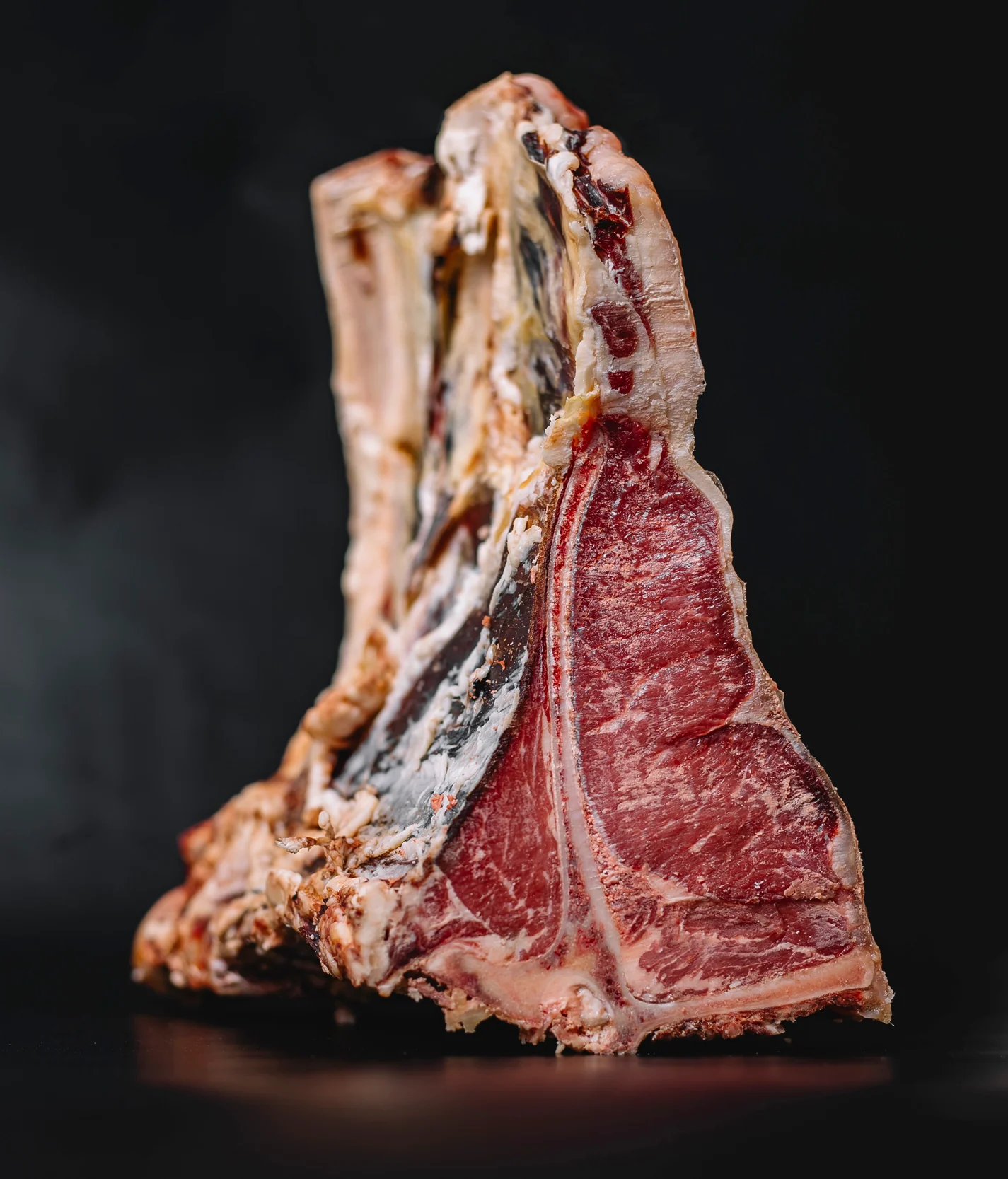 close-up-of-raw-t-bone-beef-steak-placed-on-navy-blue.webp